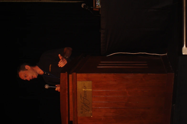 a man leaning on top of a wooden desk