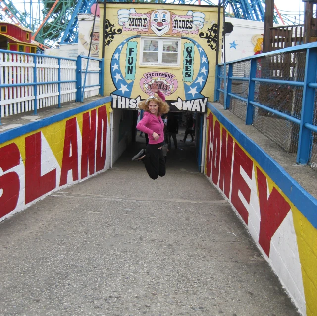 a woman in pink jacket jumping from a carnival carnival ride