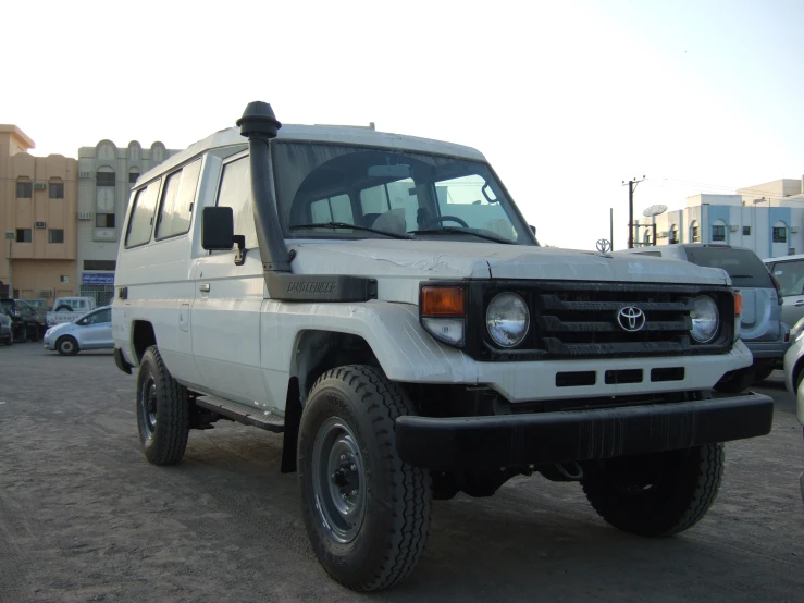 a white, parked toyota patrol truck in a parking lot