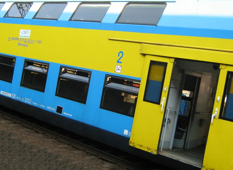 a blue and yellow train has open doors