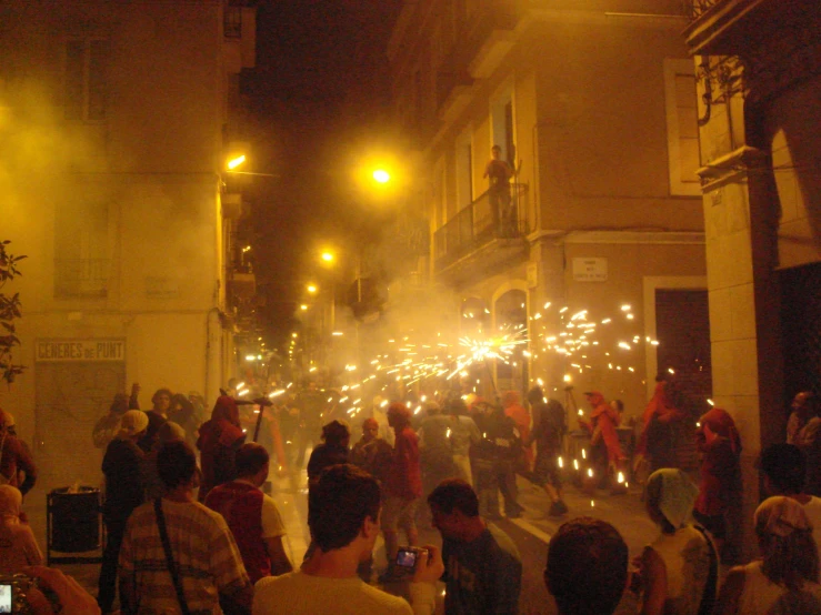 people holding torches walking down the street at night