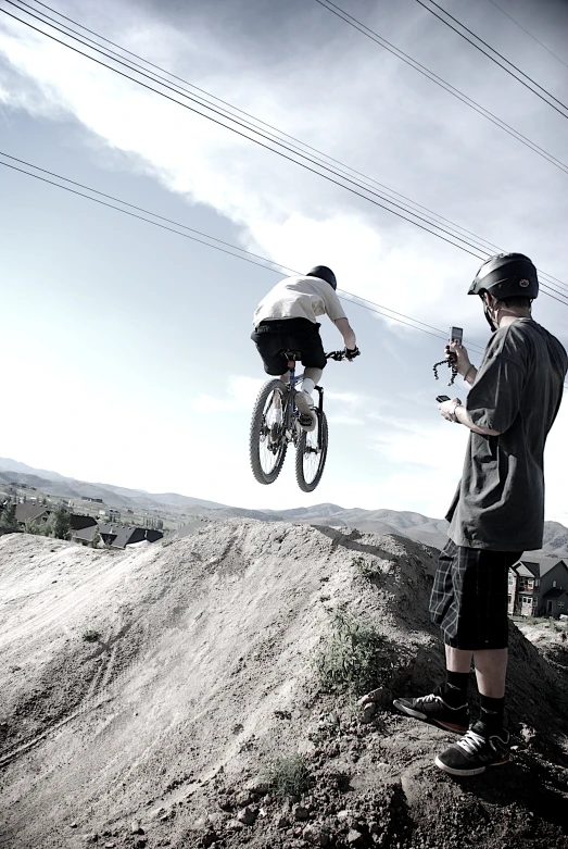 two young men jumping on bikes over an obstacle