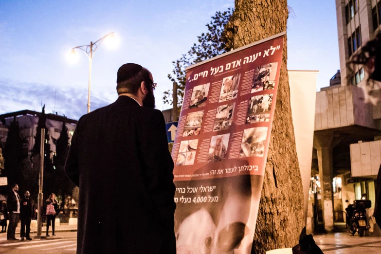 man standing in front of a poster with pictures