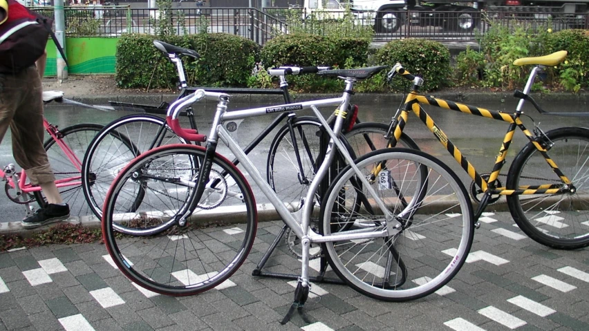 two bikes parked on the side of a road next to a pedestrian