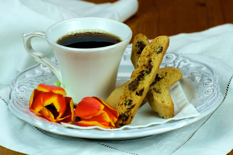 a glass tray containing cookies and a cup of coffee