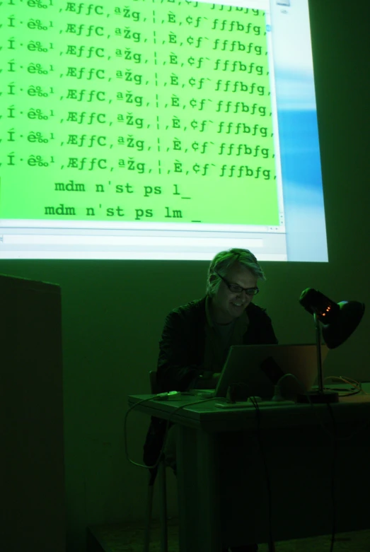 a man sitting in front of a computer on a desk