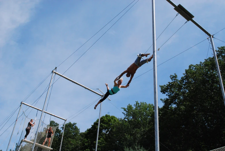 two people on a rope park with one jumping off the rope