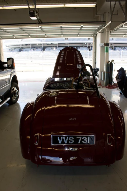 an antique sports car parked inside a garage