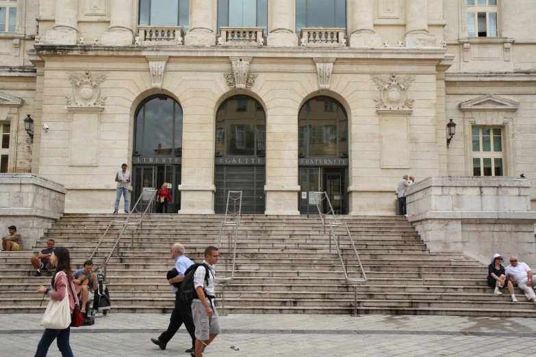 some people walking across the street near stairs