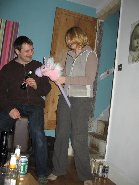 a man and woman holding teddy bear in a living room