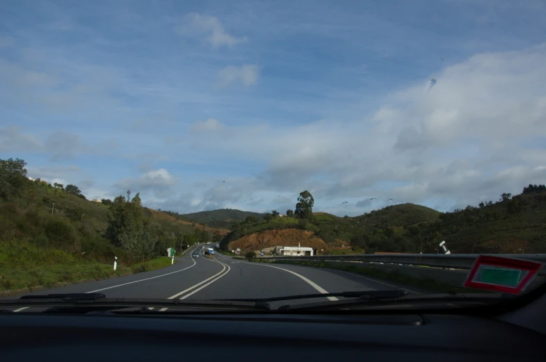 cars driving down an open highway with mountains in the distance