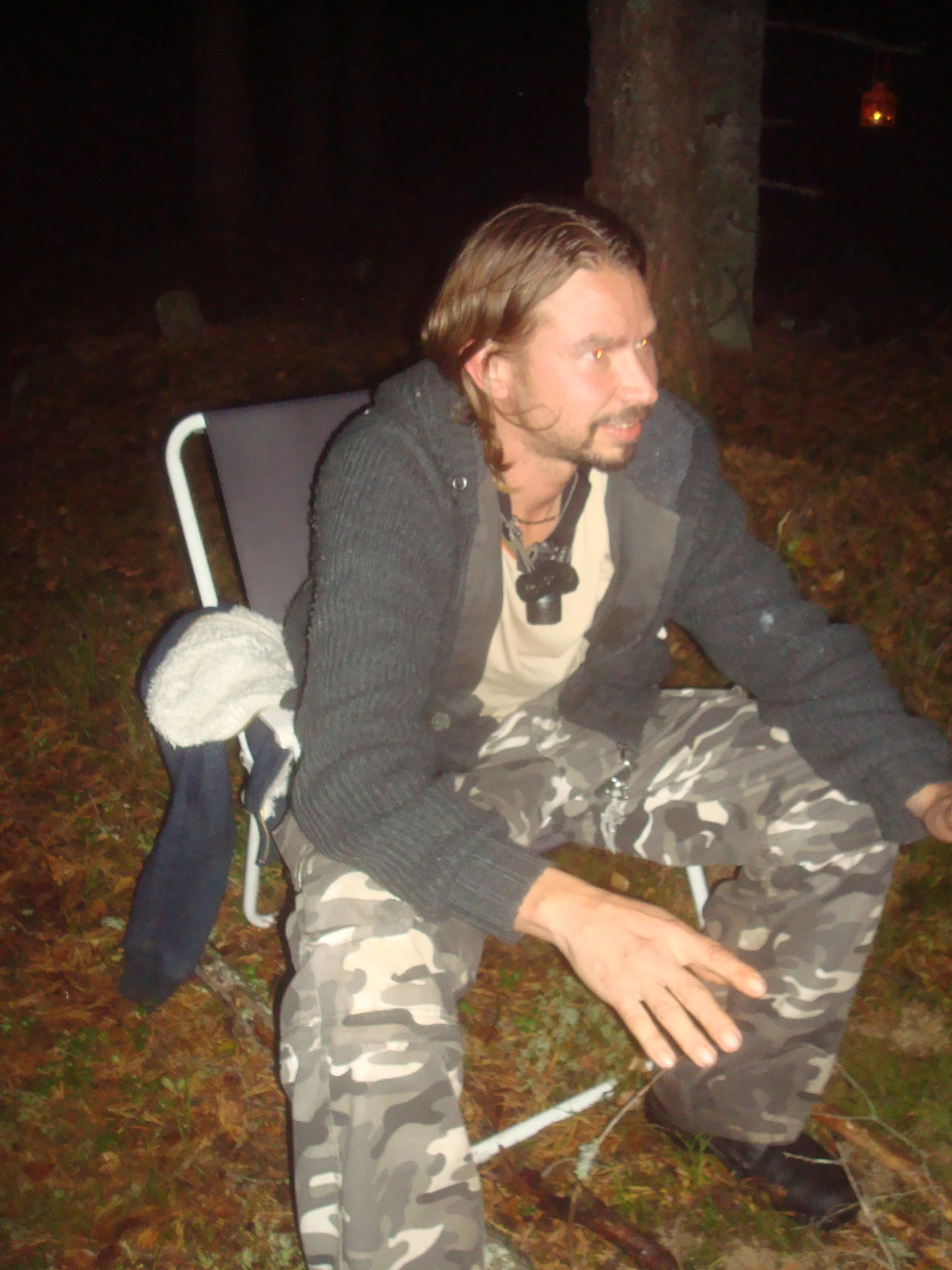 a man sitting in a chair in the woods
