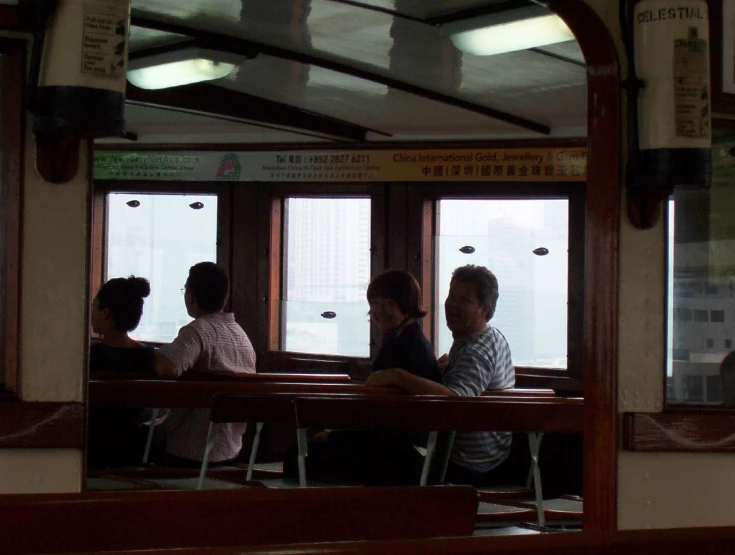 a group of people sitting on a bench near a window