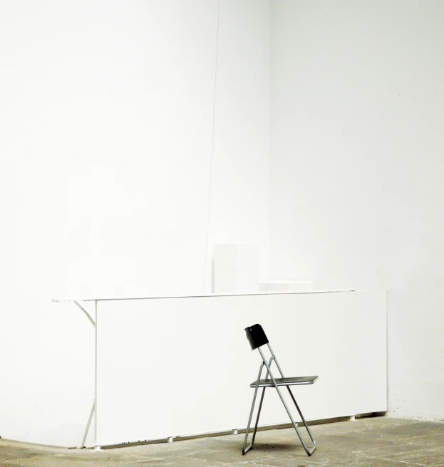 a white room with a wooden chair and a metal stand