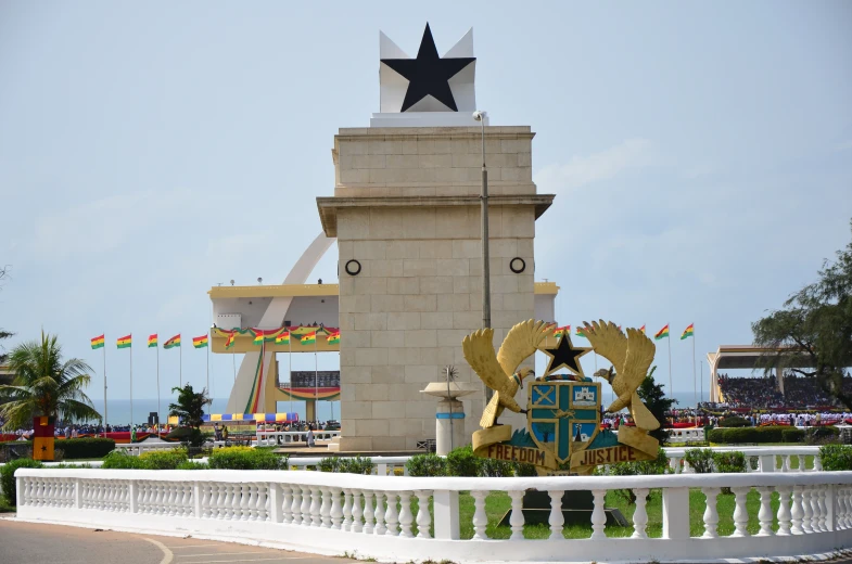 a large monument and building behind a fence