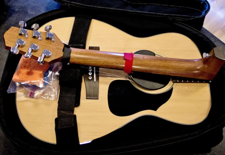 a guitar sits on a bag, its carrying the case is full