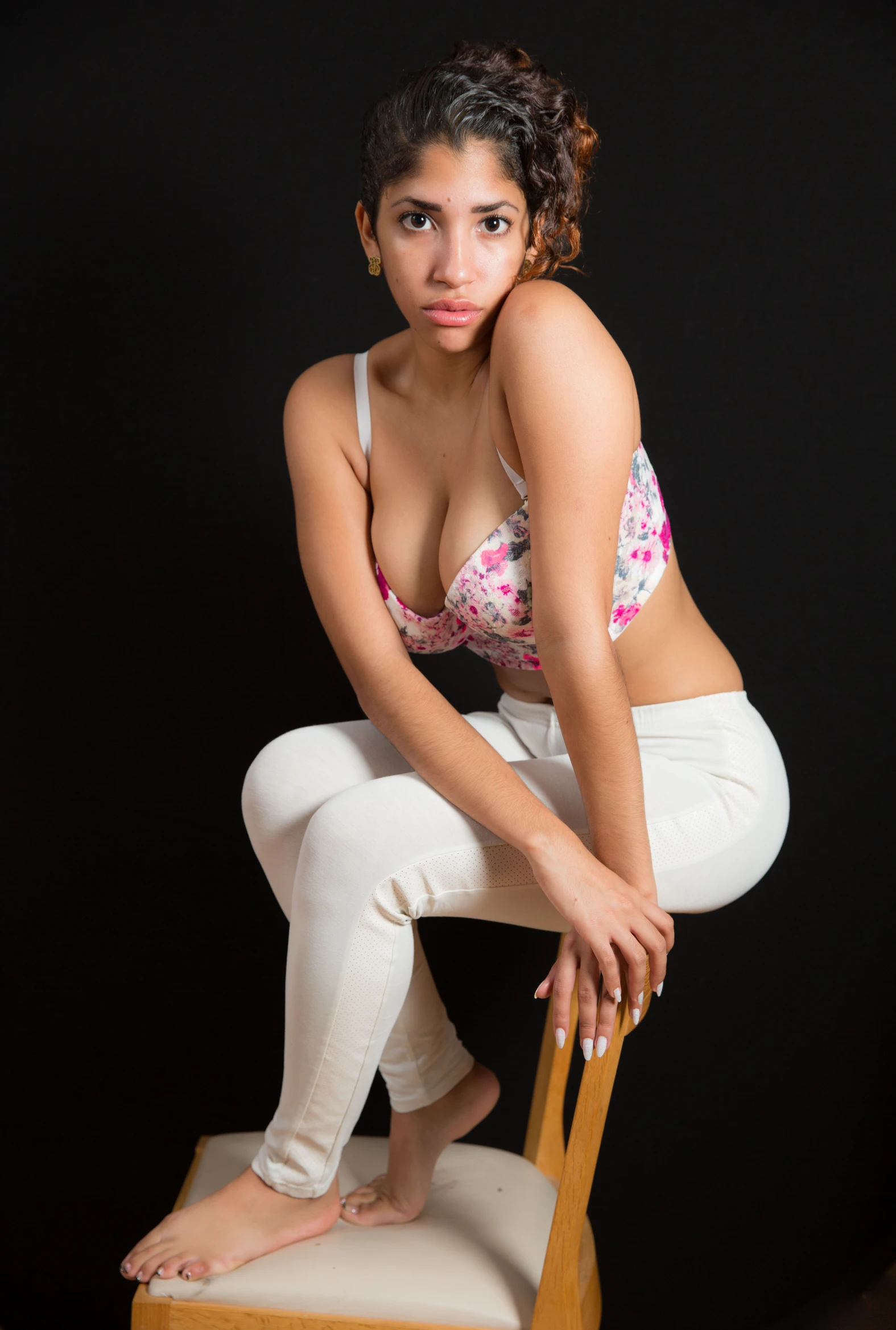 a very pretty young lady posing on a chair