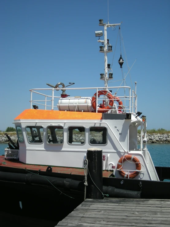 a boat docked with another boat and a water tug in the background