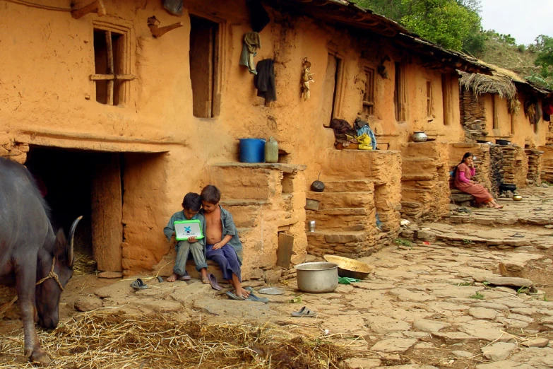 an old building with small s and animals near by