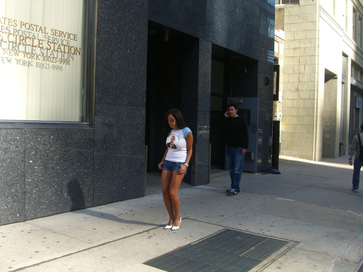 a woman standing outside of a very tall building