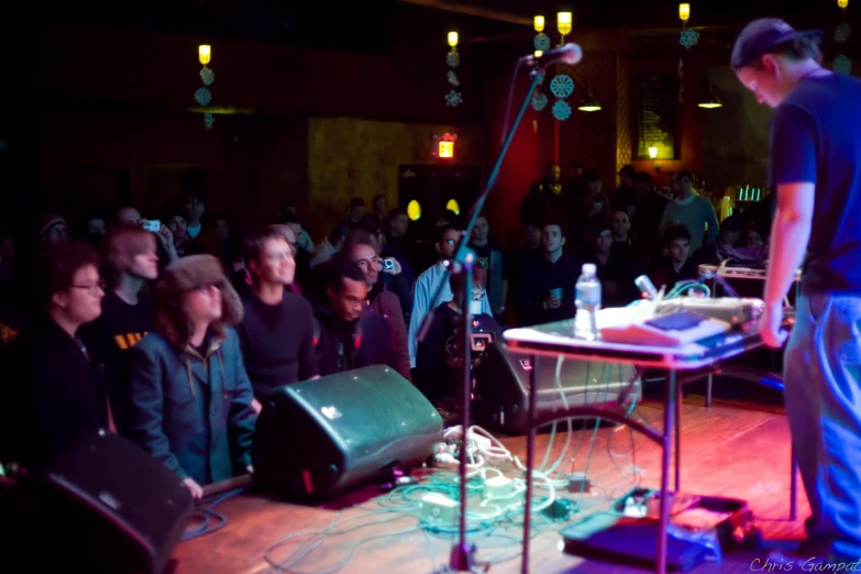 the audience watches the man talk into a microphone