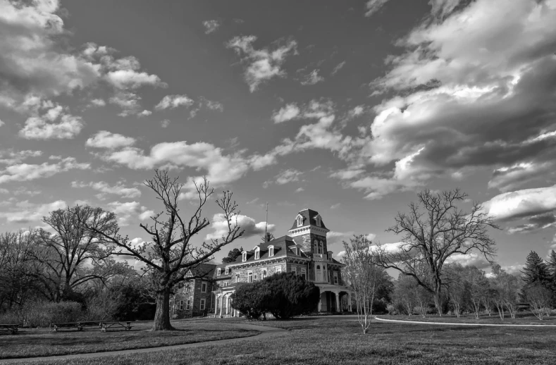 black and white pograph of a large old building with trees