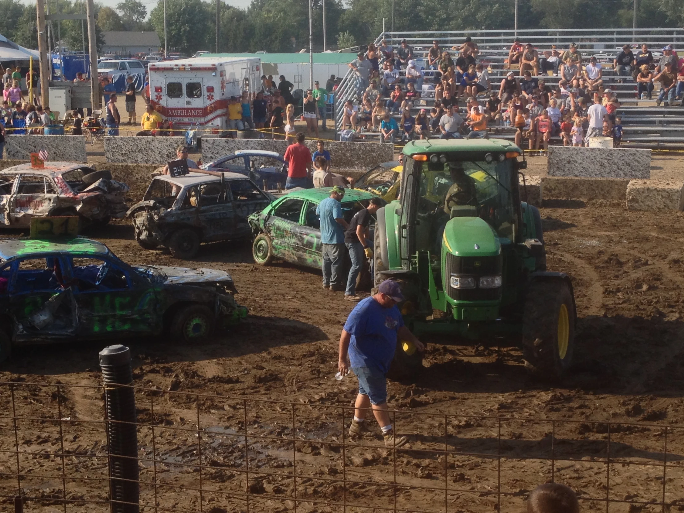 a group of people watching a tractor being pulled by two men