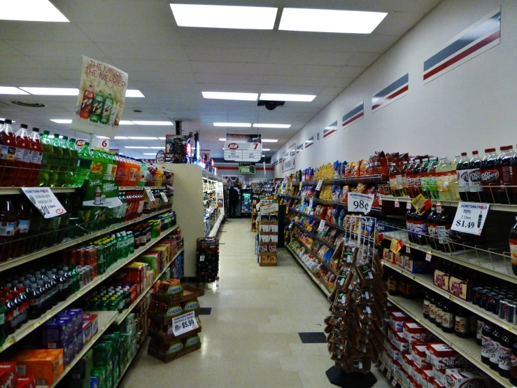 shelves full of drinks and snacks and people are shopping