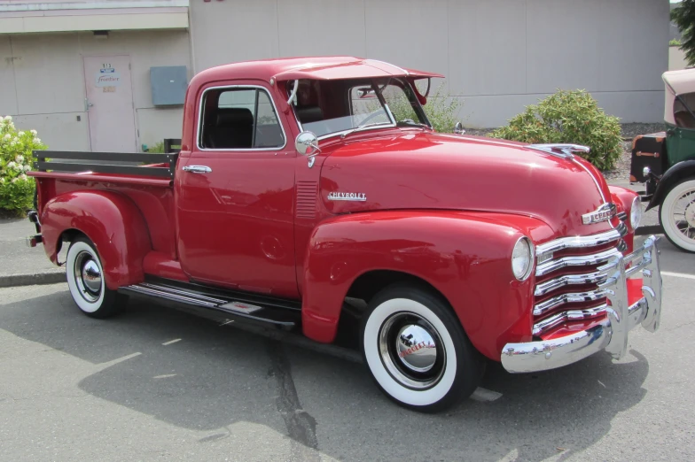 an older pickup truck parked in a parking lot