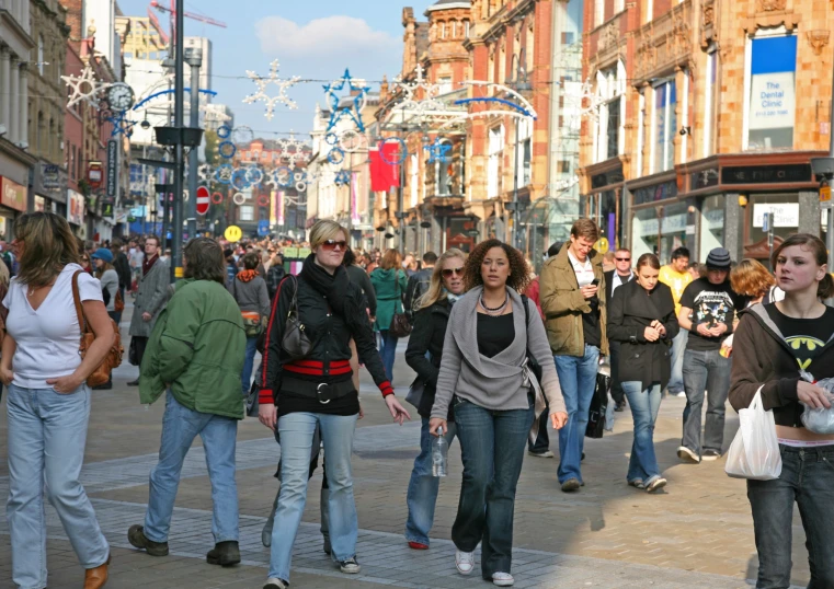 many people walk along the street in a busy area