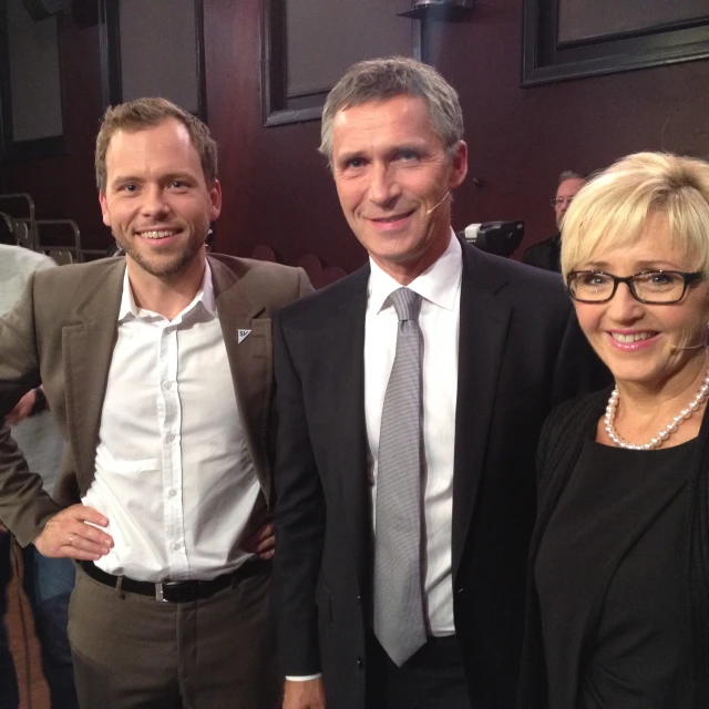 three business people smile while standing together