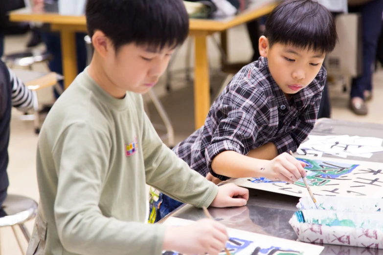 two children painting in a school classroom