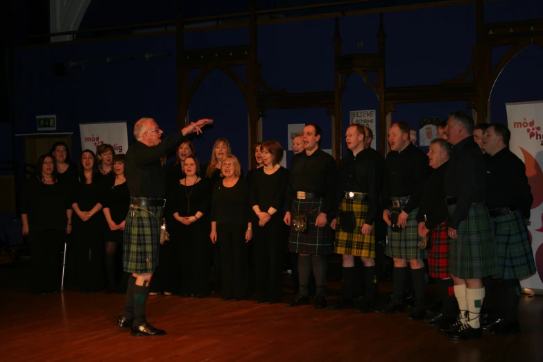 group of men and women in kilts with instruments performing