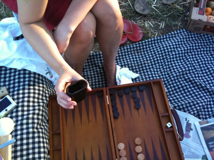 a lady plays backgam game outdoors with her tablet