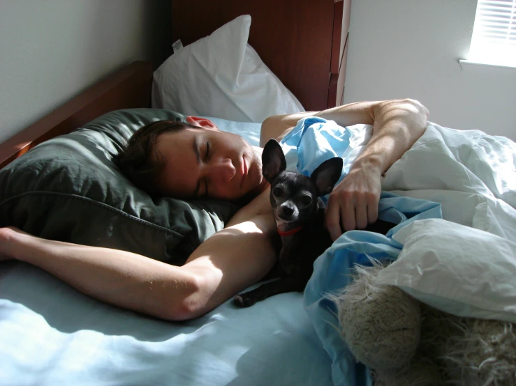 a man is lying in bed with his dog