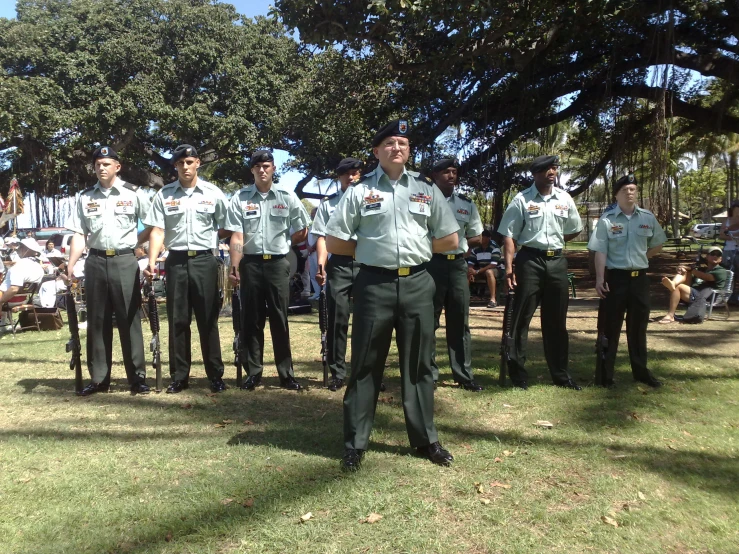 a number of men in uniform with trees in the background