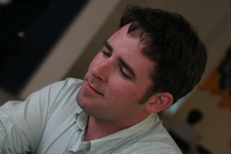 a man wearing a collared shirt with a white and green checkered