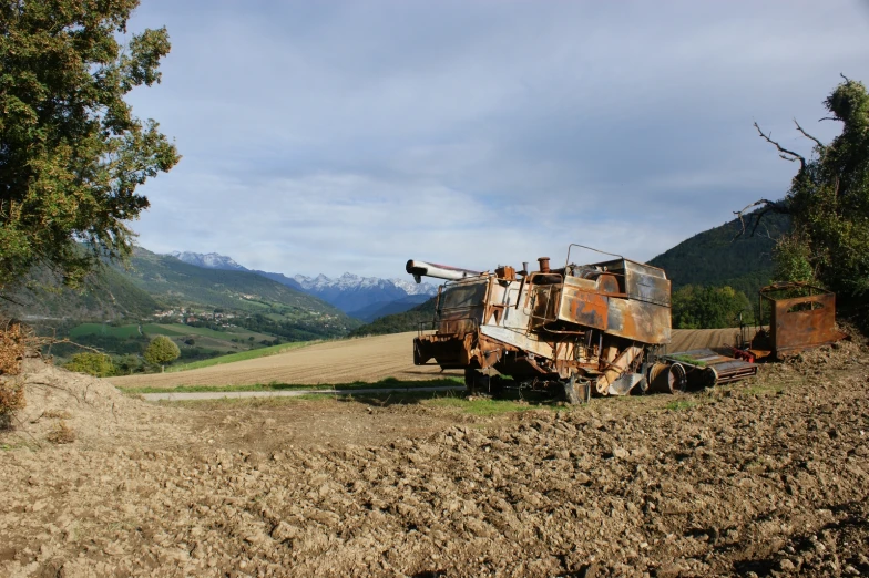 an old rusted truck in the middle of a field