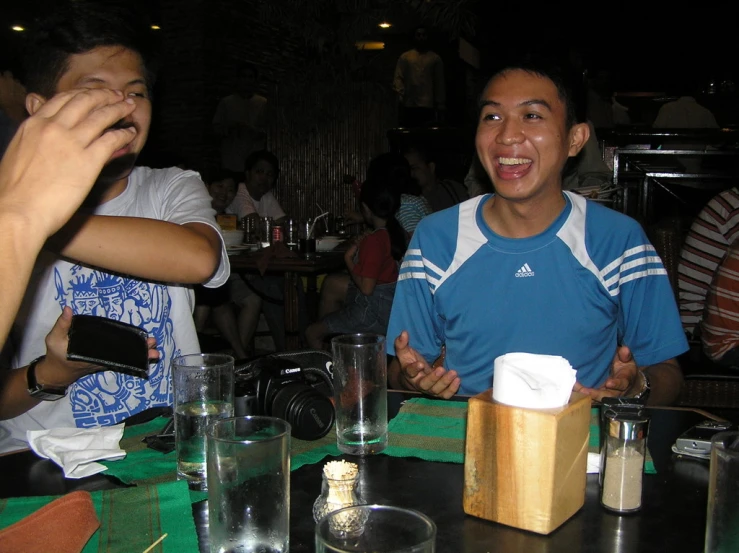 people sitting at a table eating cake and talking to each other