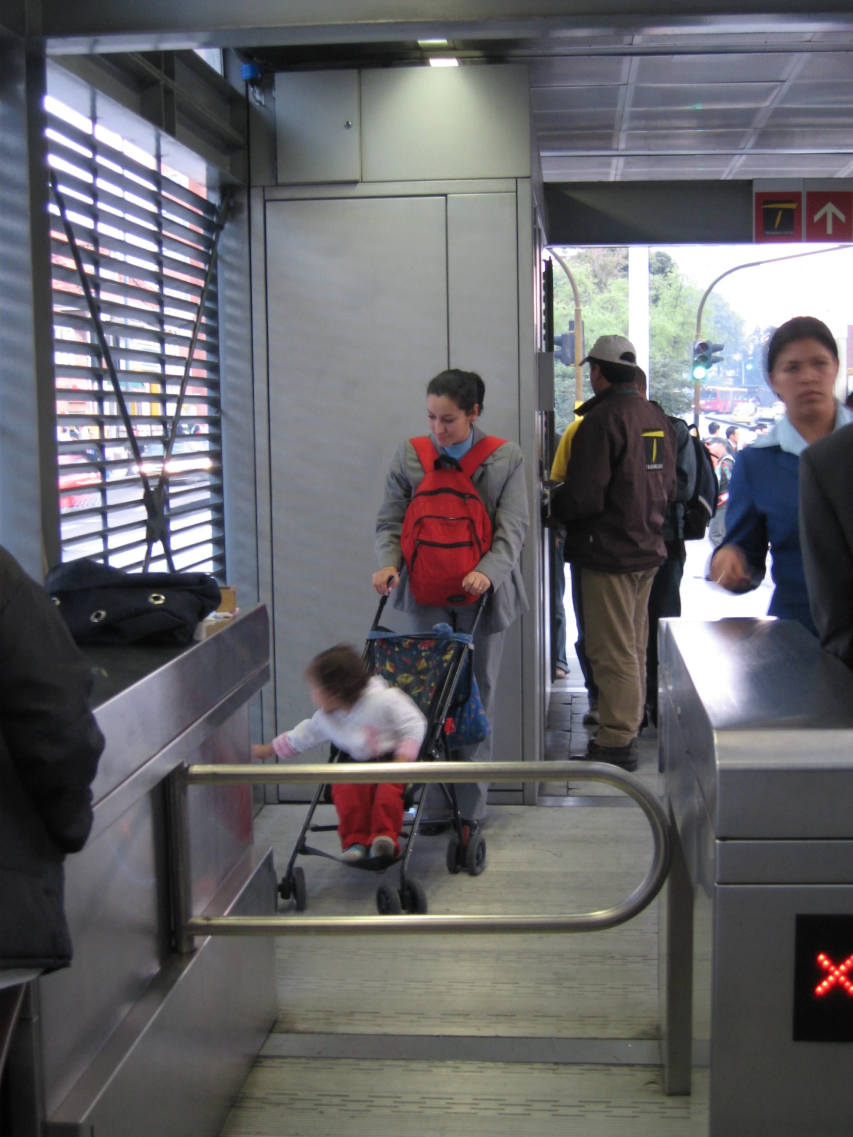 a boy in red is hing a stroller