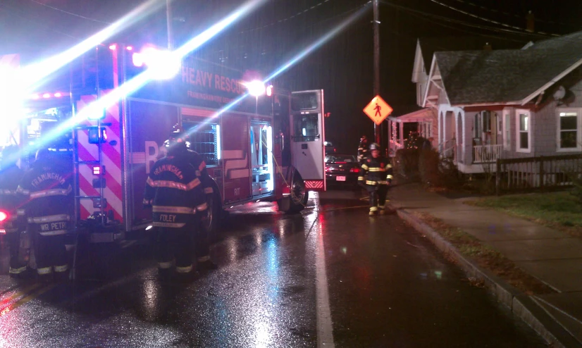 a fireman in the street leading two fire trucks