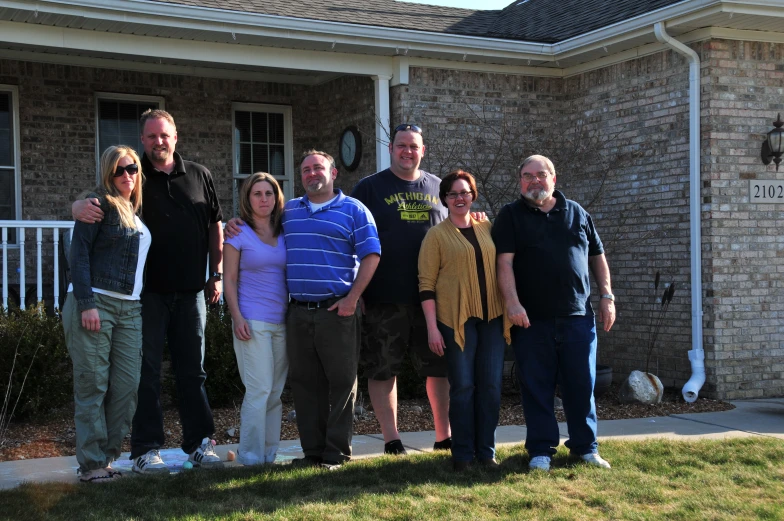 a group of people standing in front of a brick building