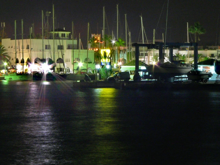 boats at dock lit up by buildings at night