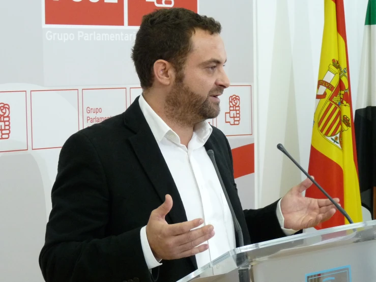 the man in a suit and tie is giving a speech