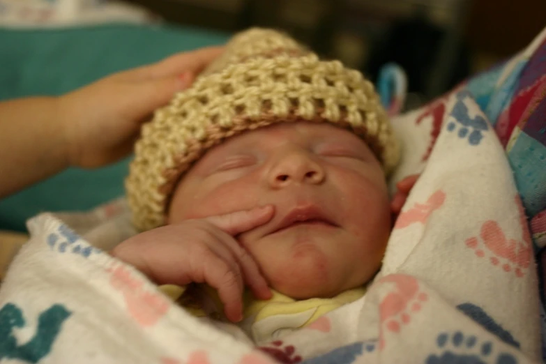 a baby wearing a crochet hat is smiling