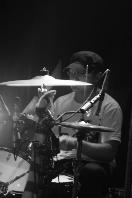 a man plays a drumset in a dark studio