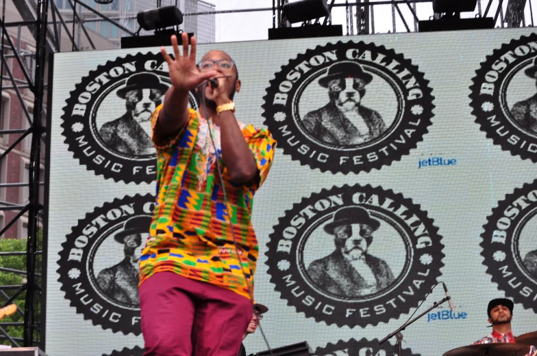 an older man in a brightly colored shirt performing on stage