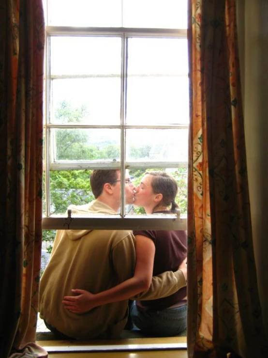 two men in front of a window looking in