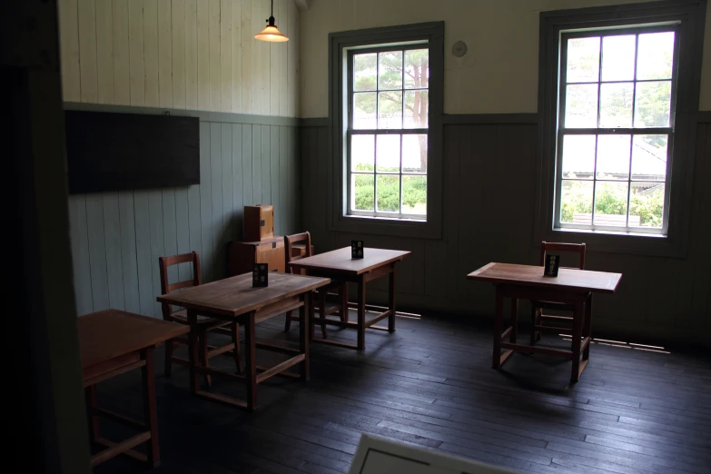 three wooden chairs sitting in front of a window