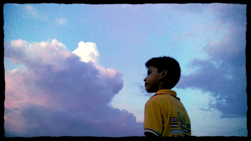 a little boy standing next to the clouds